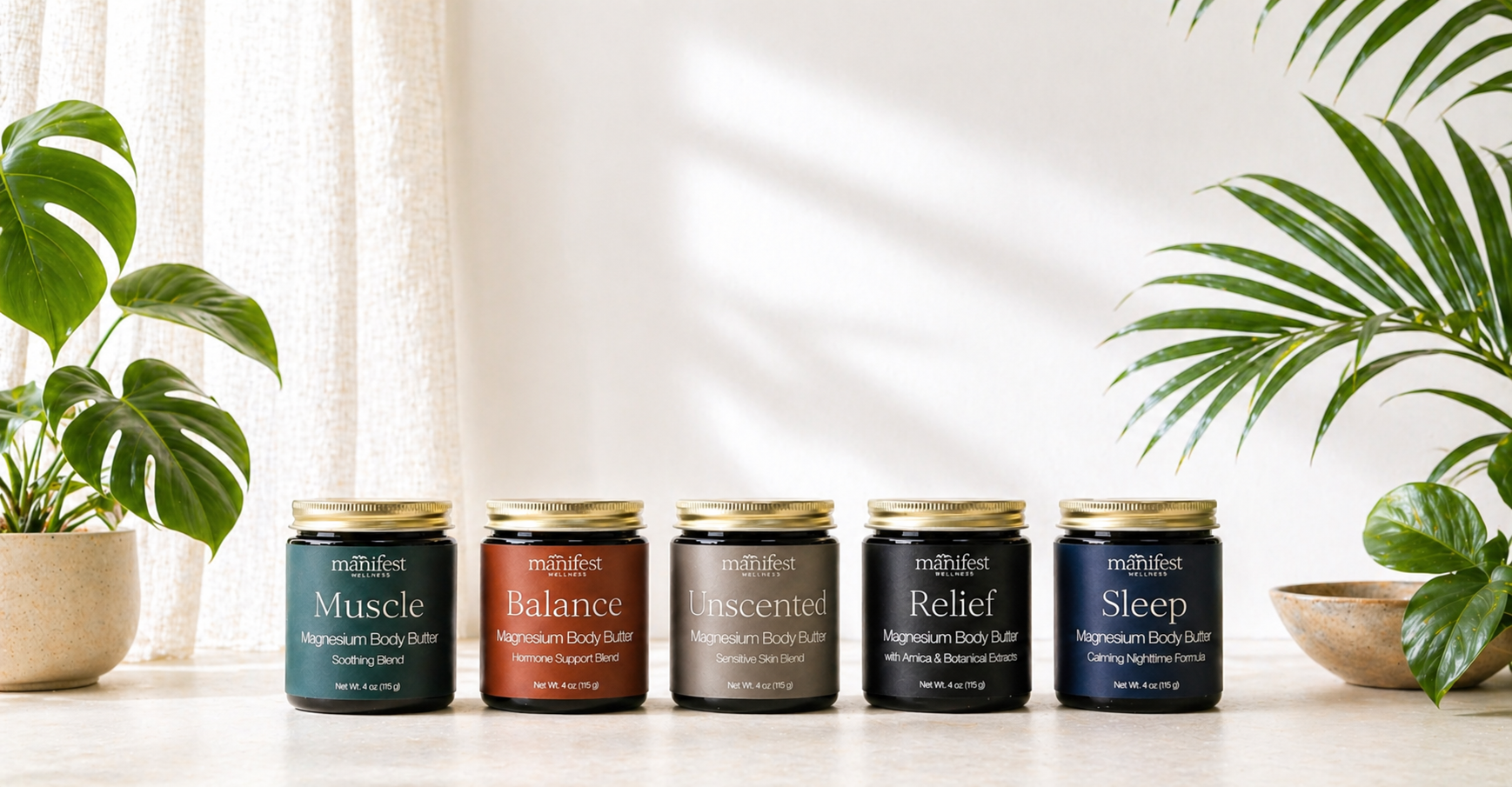 Row of Manifest Wellness Magnesium Body Butters on white surface with plants in the background
