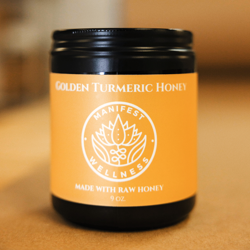 a glass jar with a black metal lid and yellow label of Golden Turmeric Honey with a golden blurred background