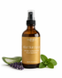 Bottle of Manifest Wellness After Sun Spray with aloe vera, lavender, and mint leaves on a white background