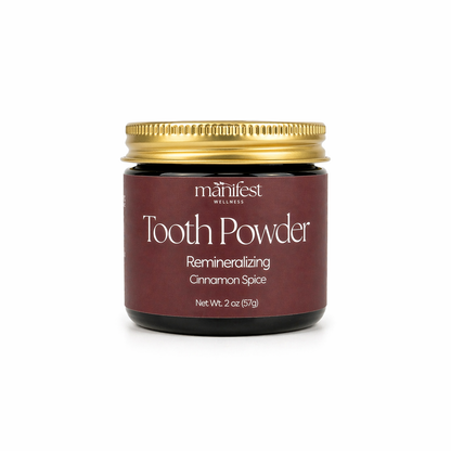Jar of Manifest Wellness Cinnamon Spice Tooth Powder with a gold lid on a white background
