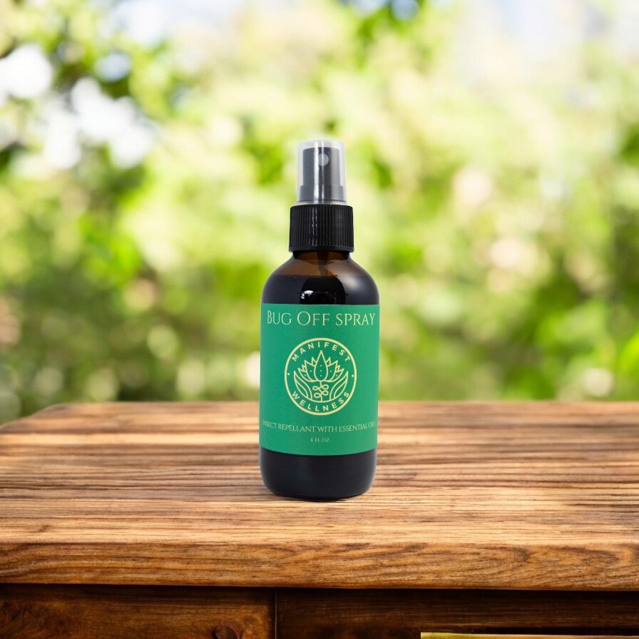 Bug spray in a glass bottle with green label on a wooden surface with blurred greenery in the background