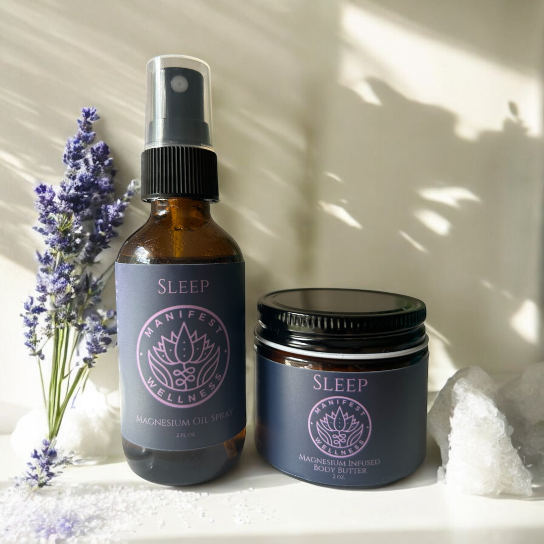The image shows a Magnesium Sleep Set consisting of a spray bottle and a jar of body butter, both with labels, placed on a surface with a sprig of lavender next to them.